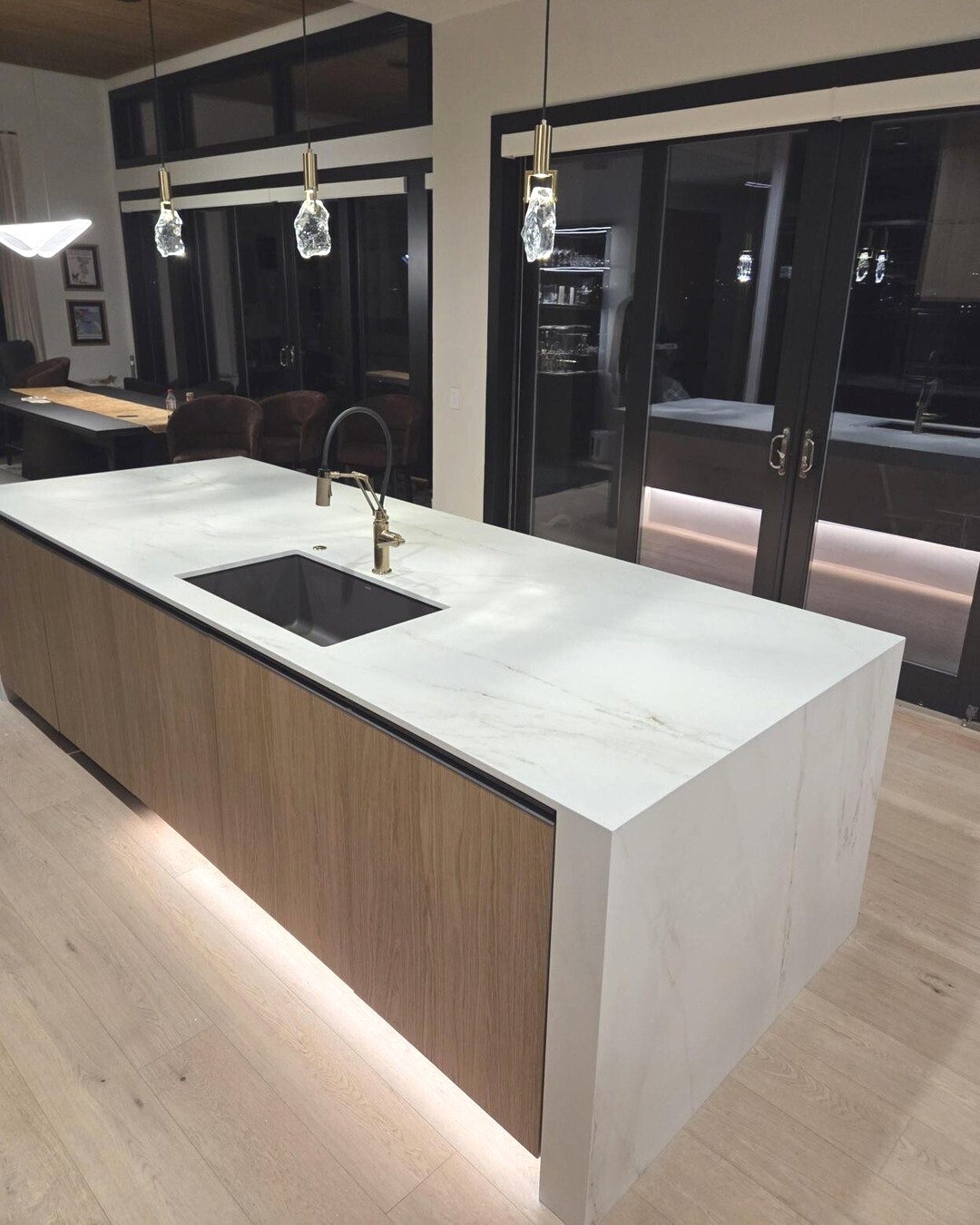Dark contemporary kitchen with a bright Dekton waterfall island